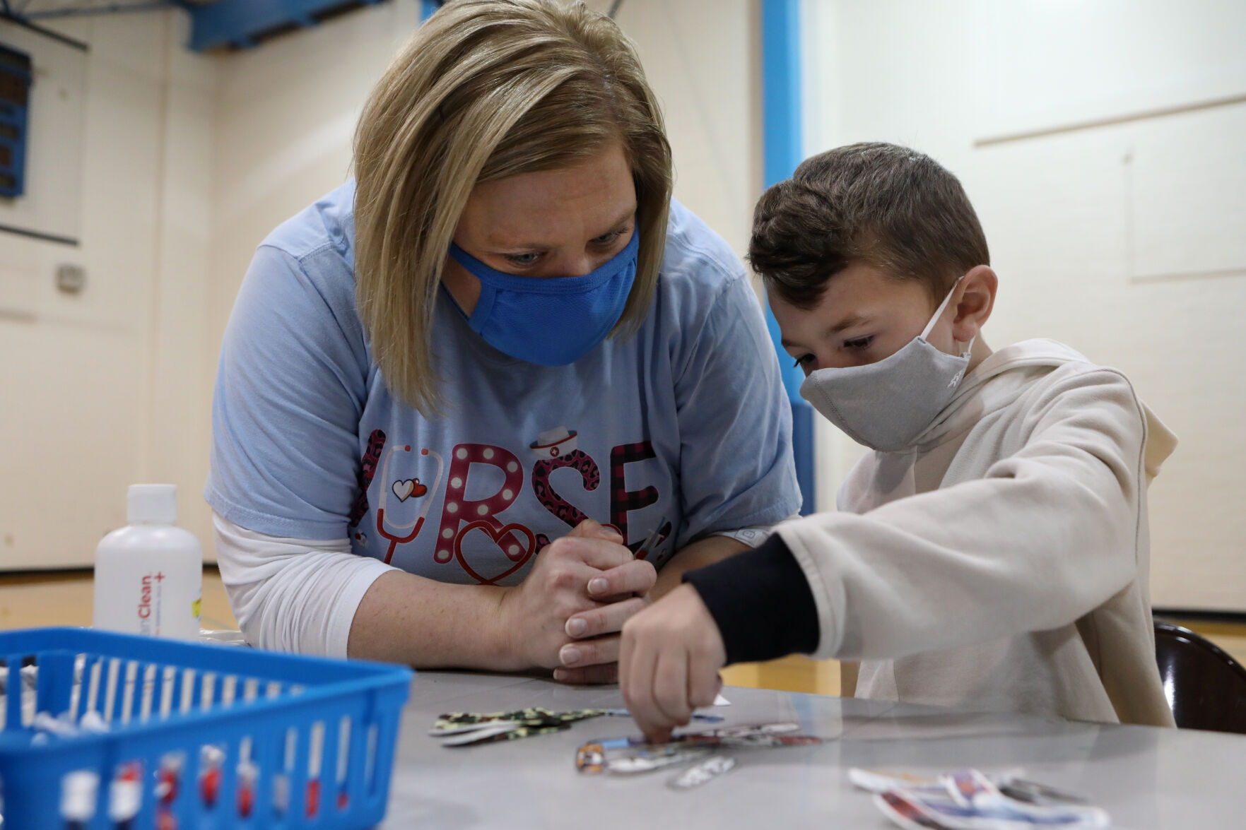 Christina Beste helps Eli Mueller pick a bandage